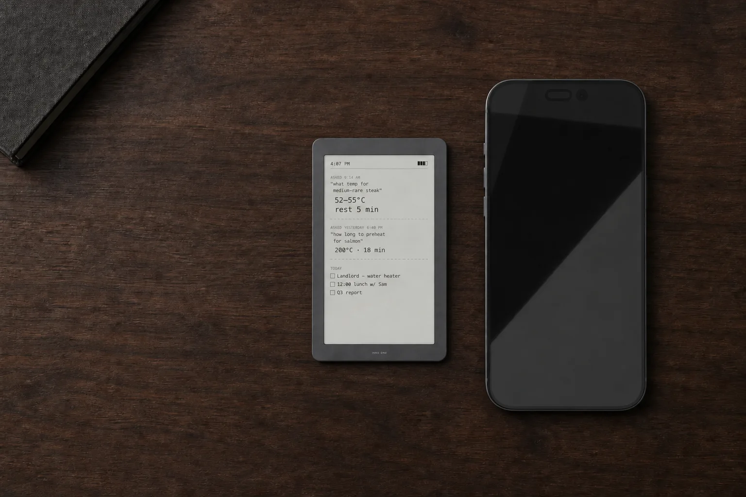 Concept of an INKQ to-do list remaining visible beside a phone with its screen off on a wooden desk